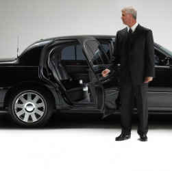 A chauffeur opening a car door. A chauffeur opening a car door.