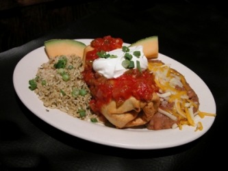 A chimichanga served with rice and refried beans. A chimichanga served with rice and refried beans.