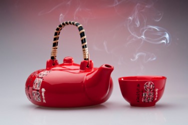 A Chinese red teapot and cup. A Chinese red teapot and cup.