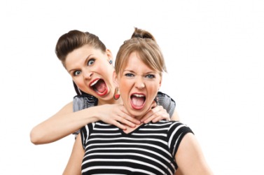 A woman pretends to choke her friend. A woman pretends to choke her friend.
