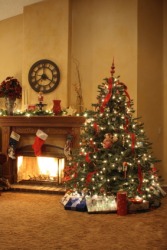 A cozy room with a Christmas tree near a warm fire. A cozy room with a Christmas tree near a warm fire.