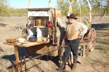 A cook standing next to his chuck wagon. A cook standing next to his chuck wagon.