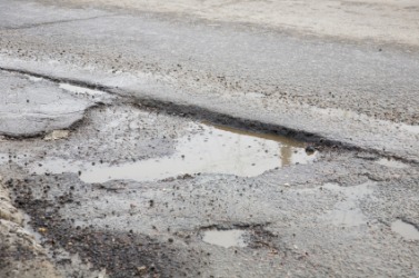 A chuckhole in a street. A chuckhole in a street.