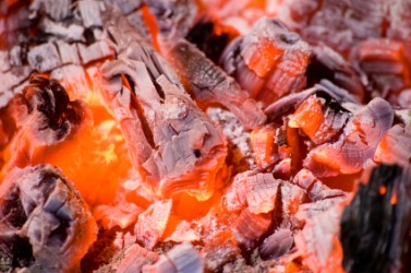 The wood in a fireplace after being reduced to cinders. The wood in a fireplace after being reduced to cinders.