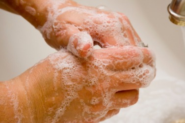 A woman washing her hands so they will be clean. A woman washing her hands so they will be clean.