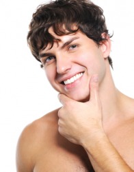 A young man admires his cleanshaven face. A young man admires his cleanshaven face.