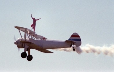 A daredevil wingwalking at an airshow. A daredevil wingwalking at an airshow.