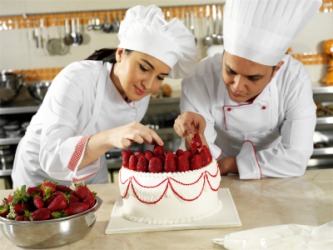 Two chefs working to decorate a cake. Two chefs working to decorate a cake.