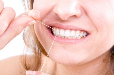 A woman using dental floss. A woman using dental floss.
