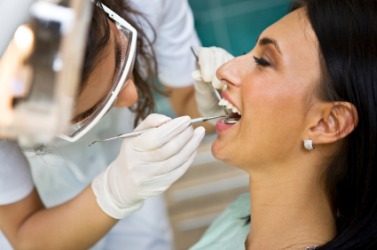 A woman getting a dental exam. A woman getting a dental exam.
