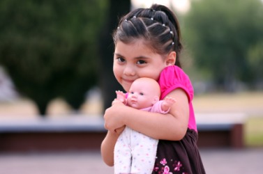 A little girl hugs her dolly. A little girl hugs her dolly.