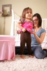 A mother helping her daughter to dress. A mother helping her daughter to dress.