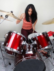 A woman playing the drums. A woman playing the drums.