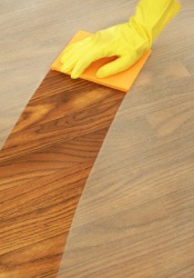 A gloved hand wiping dust from a table. A gloved hand wiping dust from a table.