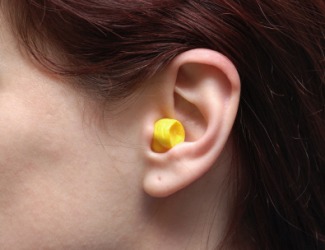 A woman using an earplug. A woman using an earplug.