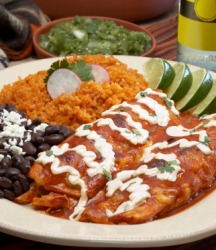 A plate of enchiladas with beans. A plate of enchiladas with beans.