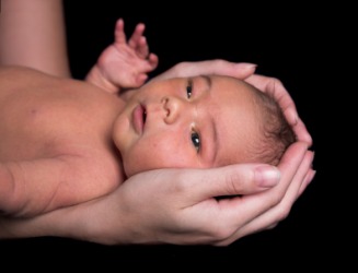 A babys head enshrined in its mothers hands. A babys head enshrined in its mothers hands.