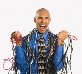 A man entangled in computer cables. A man entangled in computer cables.