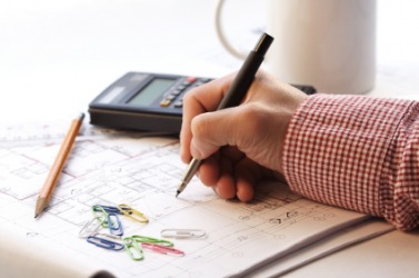 A businessman works on an estimate for a building project. A businessman works on an estimate for a building project.