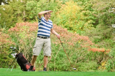 A man conducts an exhaustive search for his golf ball. A man conducts an exhaustive search for his golf ball.