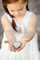 A little girl extends her arms to offer a gift. A little girl extends her arms to offer a gift.