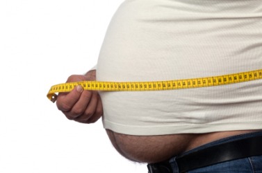 A man measures his fat belly. A man measures his fat belly.
