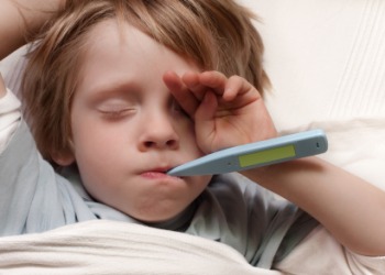 A child with a fever has his temperature taken. A child with a fever has his temperature taken.