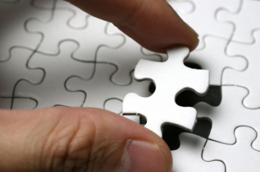 Placing the final piece to finish a puzzle. Placing the final piece to finish a puzzle.