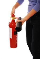 A woman holding a fire extinguisher. A woman holding a fire extinguisher.