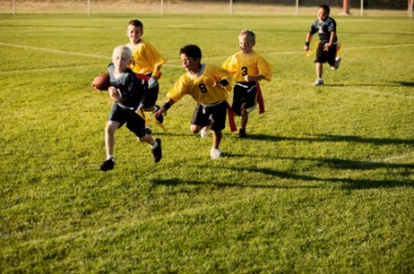 Children playing flag football. Children playing flag football.