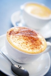 A cup of coffee topped with frothy milk. A cup of coffee topped with frothy milk.