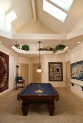 A billiard table in a game room. A billiard table in a game room.