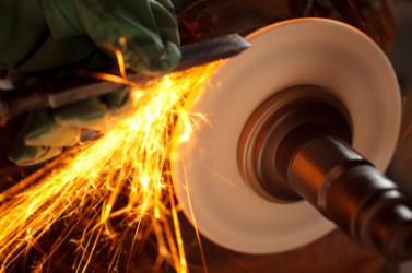 A grindstone being used to sharpen a chisel. A grindstone being used to sharpen a chisel.
