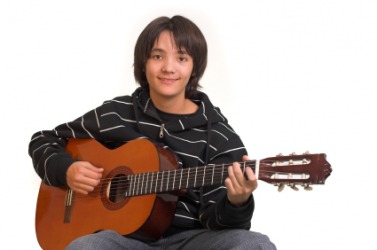 A boy playing a guitar. A boy playing a guitar.