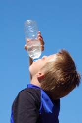 A thirsty boy guzzles water. A thirsty boy guzzles water.