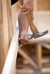 A construction worker hits the nail on the head. A construction worker hits the nail on the head.
