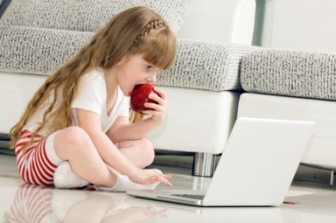 A little girl using a home computer. A little girl using a home computer.