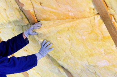 A man installs insulation in a building. A man installs insulation in a building.