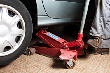 A jack being used to lift a car. A jack being used to lift a car.