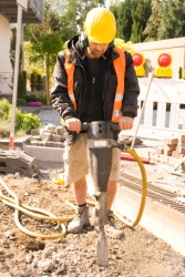 A man using a jackhammer. A man using a jackhammer.