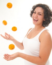 A woman juggles tangerines. A woman juggles tangerines.