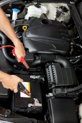 A mechanic prepares to jump-start an automobile engine. A mechanic prepares to jump-start an automobile engine.