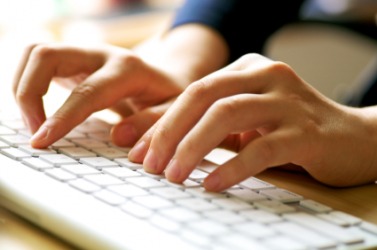 A person using a computer keyboard. A person using a computer keyboard.