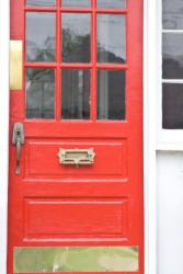 A red door with a brass kick plate. A red door with a brass kick plate.