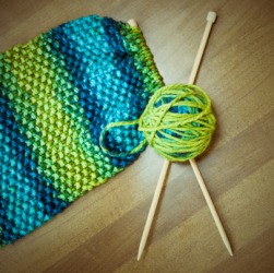 A pair of knitting needles stuck in a ball of yarn. A pair of knitting needles stuck in a ball of yarn.