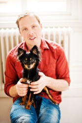 A man holding a lap dog. A man holding a lap dog.
