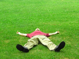 A man lies in the grass. A man lies in the grass.