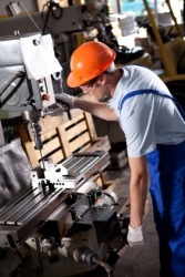 A man working in a machine shop. A man working in a machine shop.