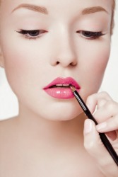 A woman applying makeup. A woman applying makeup.
