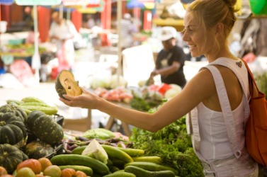 A woman shopping at a farmers market. A woman shopping at a farmers market.